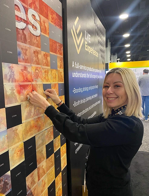 Guest placing her sticker on the mosaic